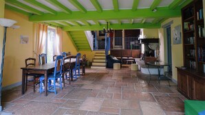 Un coin repas avec une table et des chaises, un escalier et une bibliothèque.