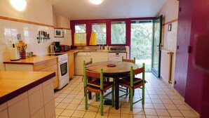 Une cuisine compacte avec un coin repas, comprenant une cuisinière, un four à micro-ondes et un évier.