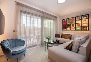 Appartement, privézwembad | Woonruimte | Een 33-inch smart-tv met satellietzenders