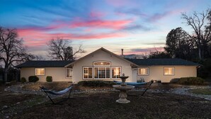 A single-story house with a gabled roof, a front porch, and a large front window. - New! Big Sky Cabin at Yosemite w/ VIEWS, hot tub, firepit, and more! (Oakhurst)