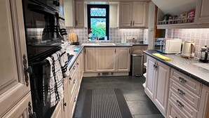 A kitchen with a stove, oven, sink, and cabinets. - Cozy Aberdeen Cottage With 3 Bedrooms (Aberdeen)