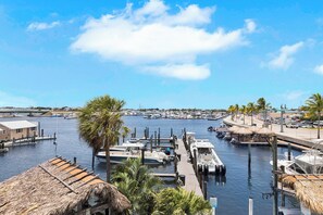 A marina with boats docked, a thatched-roof structure, and a clear sky. - Waterfront Dock Pool Downtown Near Duval Pet (Key West)