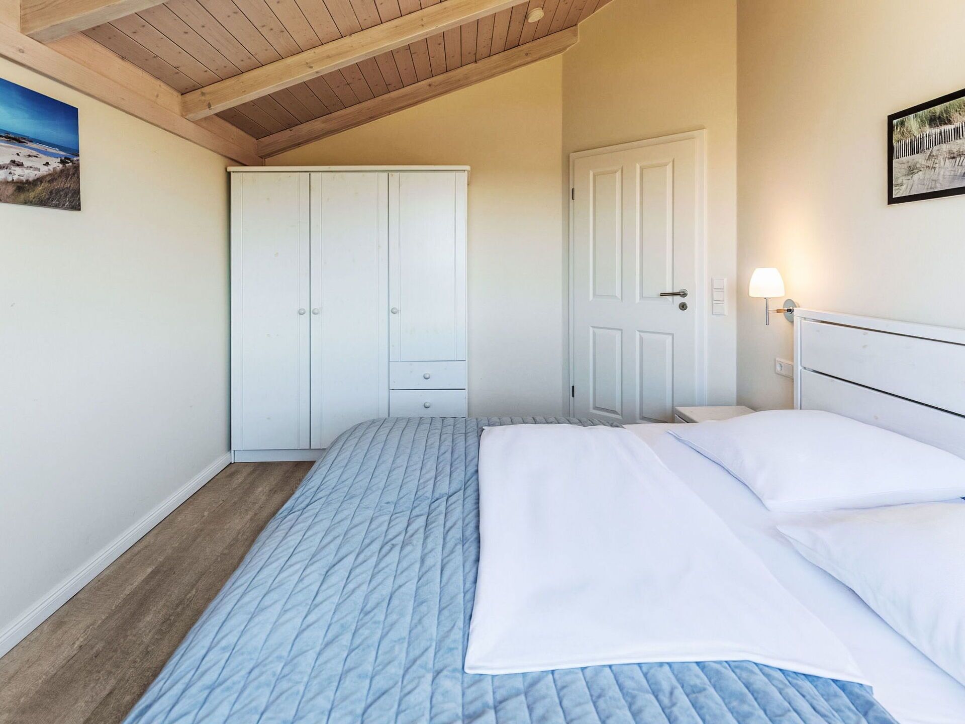 A bedroom with a bed, a wardrobe, and a door.