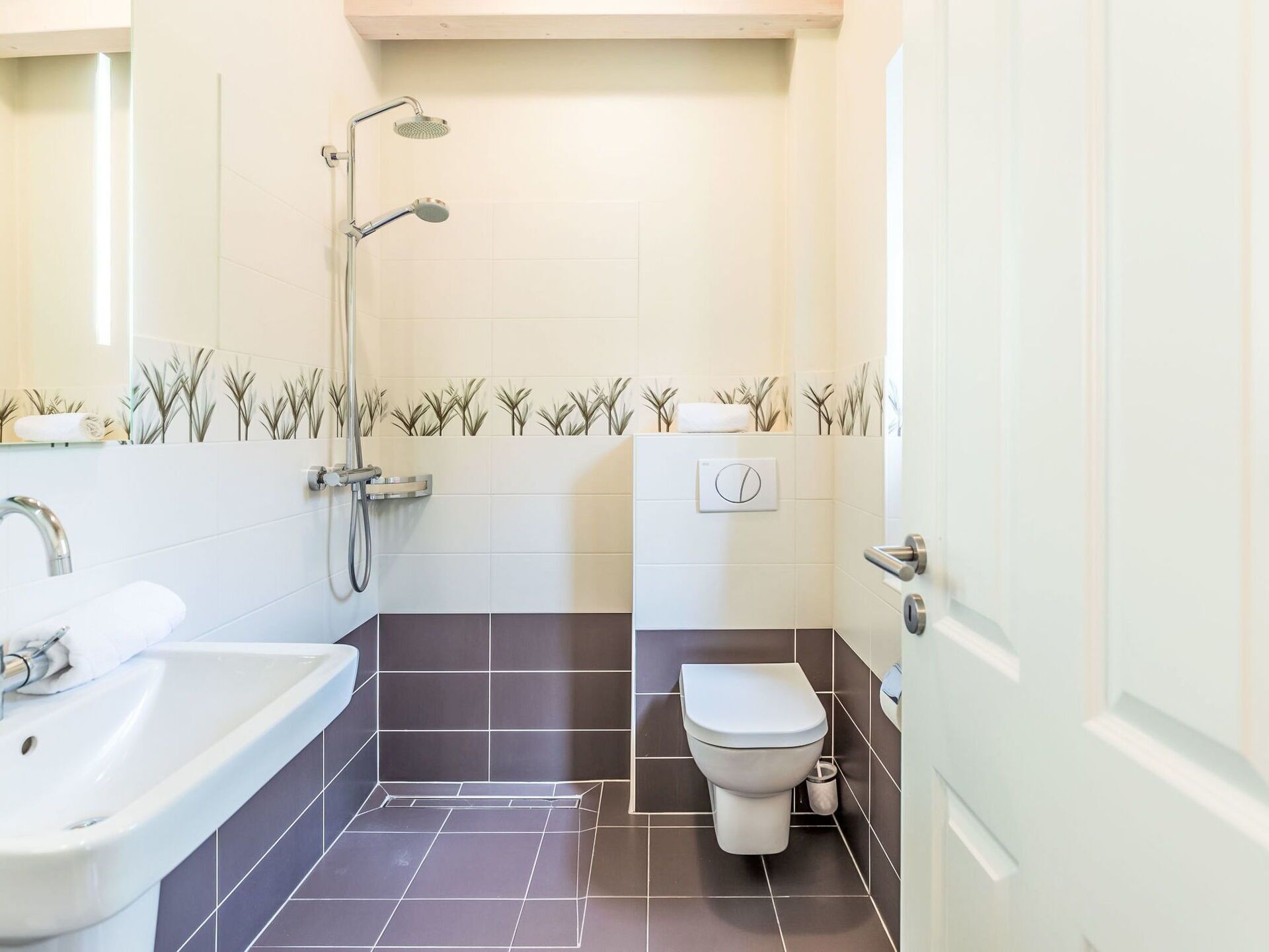 Une salle de bain moderne équipée d’une douche, de toilettes et d’un lavabo.