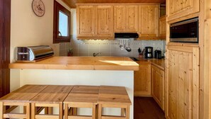 Una cucina con mobili in legno, forno a microonde integrato e un tostapane.