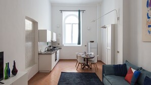 Ein kompakter Wohnbereich mit Küchenzeile, Essplatz und einer Couch.