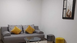 A living room with a grey sofa, a round coffee table, a rug, and a framed artwork on the wall. - Beautiful apartment in a quiet neighborhood (Maxhütte-Haidhof)