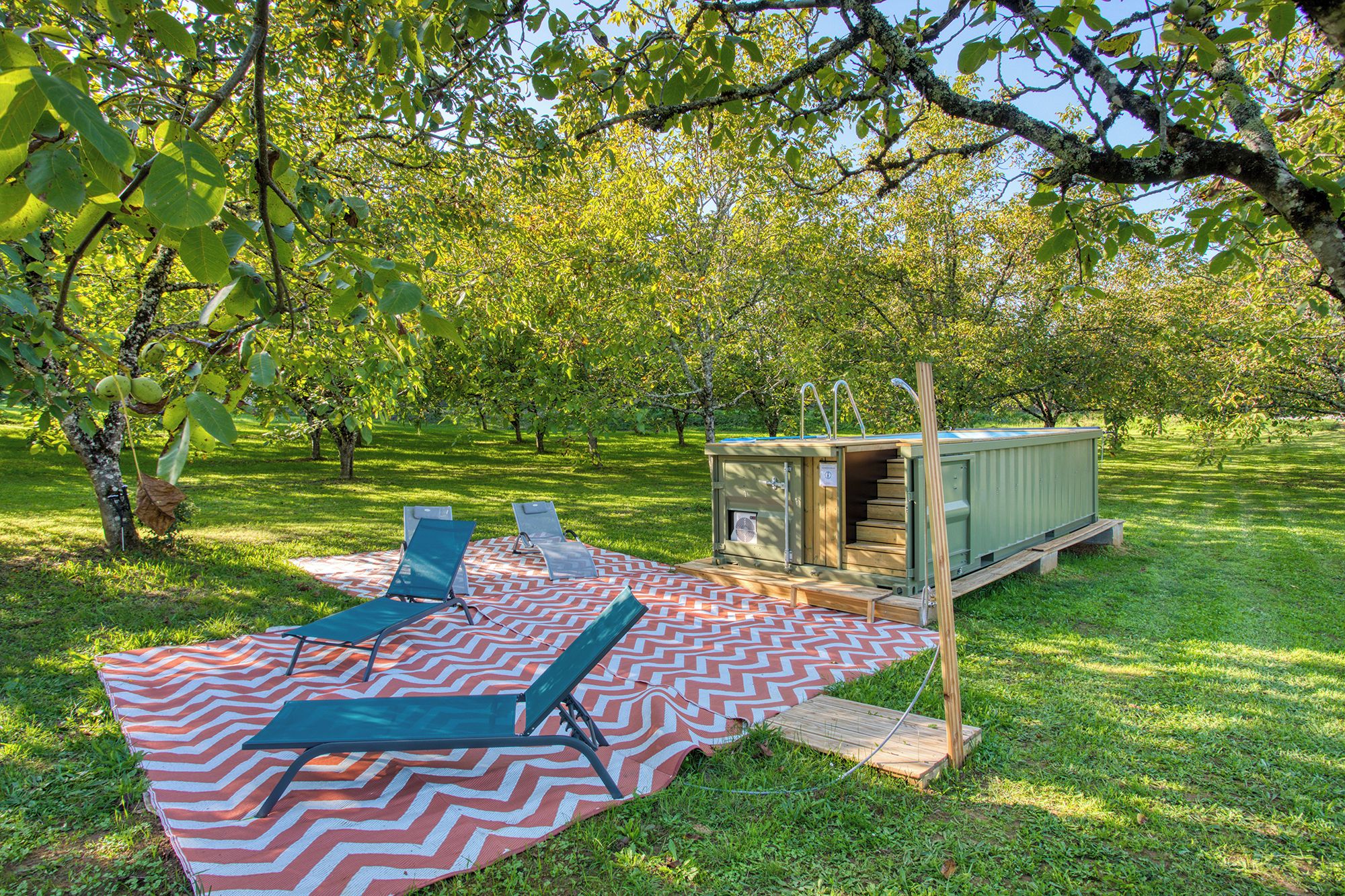 An outdoor setting with a picnic table, chairs, and a small wooden structure.