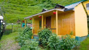 Una baita di legno con un portico, immersa nel verde.