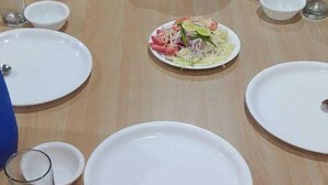 Un tavolo apparecchiato con piatti, ciotole e una pentola grande, probabilmente per un pasto.