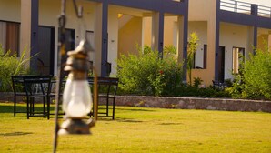 A building with multiple balconies and a well-maintained lawn. - Ranthambore Village Serai (Sawai Madhopur)