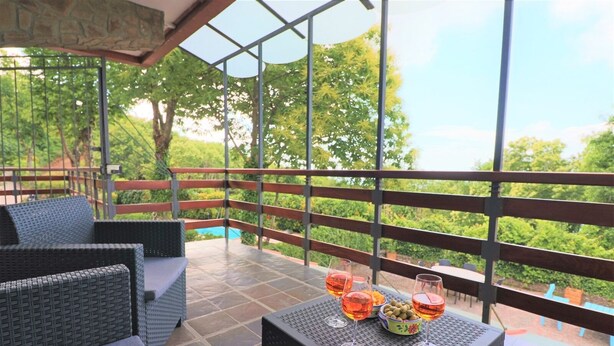 A covered outdoor seating area with wicker furniture and a table with drinks and snacks. - Villa Lalla (Sorrento)