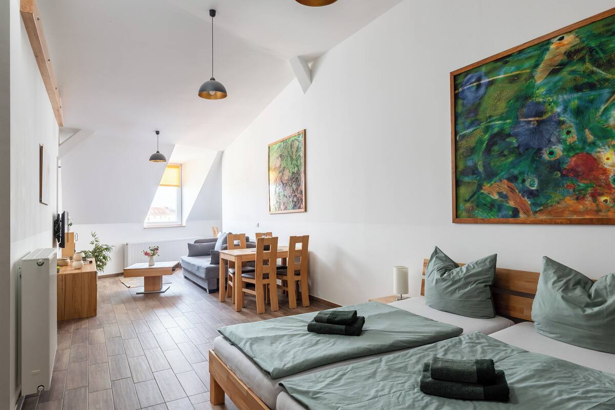 Une chambre moderne avec un lit en mezzanine, un coin repas et un grand tableau.