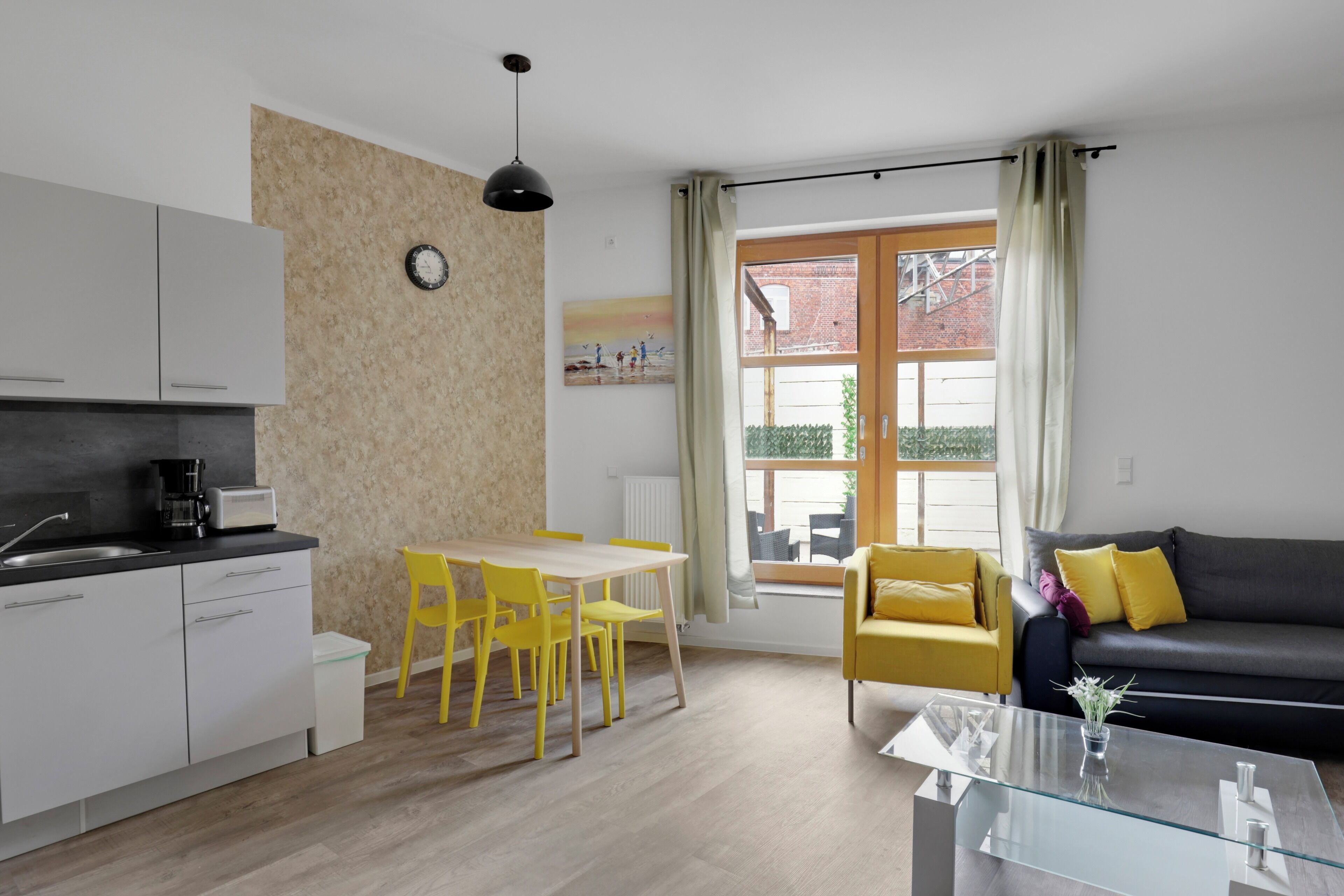 A compact living space with a kitchenette, dining area, and seating area.