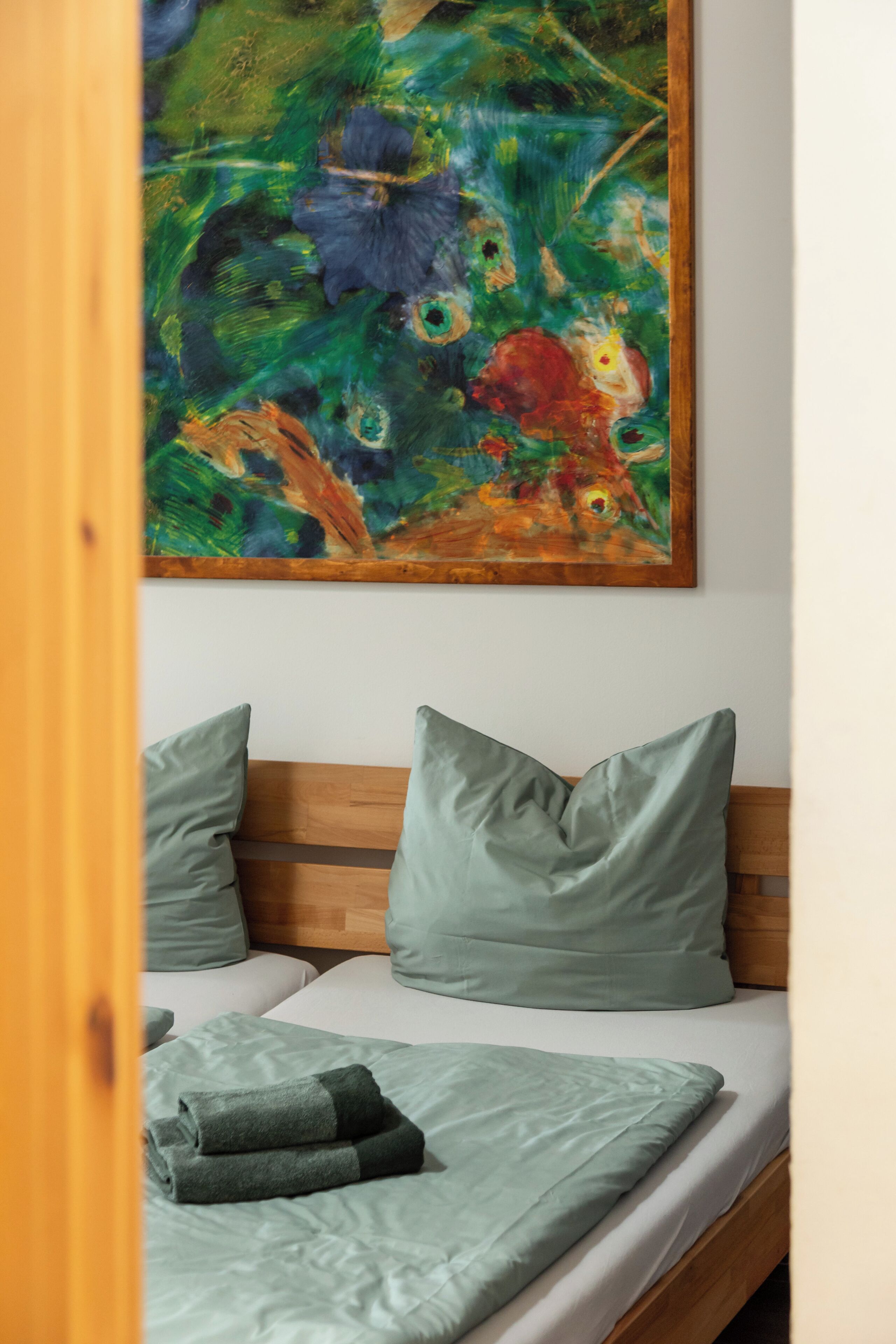 A bed with a wooden headboard, two pillows, and a blanket.