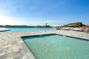 Una piscina con agua cristalina, un borde de baldosas y sillas de descanso.