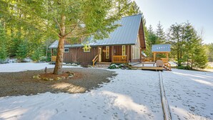 Eine Holzhütte mit einem Metalldach und einer Veranda, auf der sich eine Bank befindet.