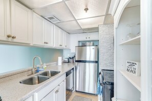 A modern kitchen with white cabinets, stainless steel appliances, and a sign indicating the kitchen is closed.