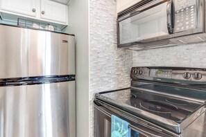A kitchen with a stainless steel refrigerator, a microwave, and a stove. - Gulf-view Balcony: Beachfront Condo in Pcb! (Panama City Beach)