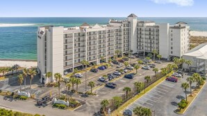 A multi-story hotel with a parking lot, located near a beach. - Grand Pointe 512 | 5th Floor Gulf-Front Condo w/ Panoramic Views & (Orange Beach)
