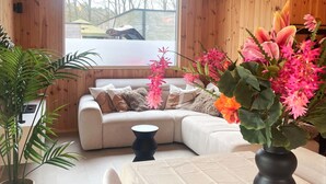 A modern living room with a sectional sofa, a round coffee table, and a potted plant. - Zutendaal Forest Retreat (Zutendaal)