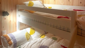 A bunk bed with a white frame and a lower bed with colorful blankets. - Zutendaal Forest Retreat (Zutendaal)