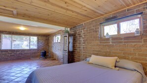 A bedroom with a bed, wooden ceiling, brick walls, and a window with a view. - 4 Mi to Lake Wohlford: Cabin in Escondido (Valley Center)
