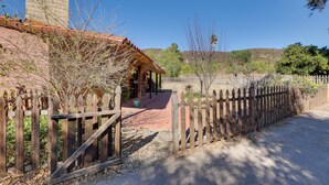 A rustic building with a red-tiled roof, a wooden fence, and a gravel path leading to a covered patio area. - 4 Mi to Lake Wohlford: Cabin in Escondido (Valley Center)