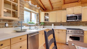 A kitchen with wooden cabinets, a stainless steel microwave, and a built-in oven. - 4 Mi to Lake Wohlford: Cabin in Escondido (Valley Center)