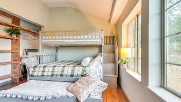 Habitación con literas, estantes de madera y una planta.