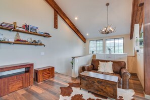 A spacious living area with a wooden ceiling, a brown leather sofa, a wooden coffee table, and a cowhide rug. - Pristine Cabin, Breathtaking Views in Aspen Grove (Black Hawk)