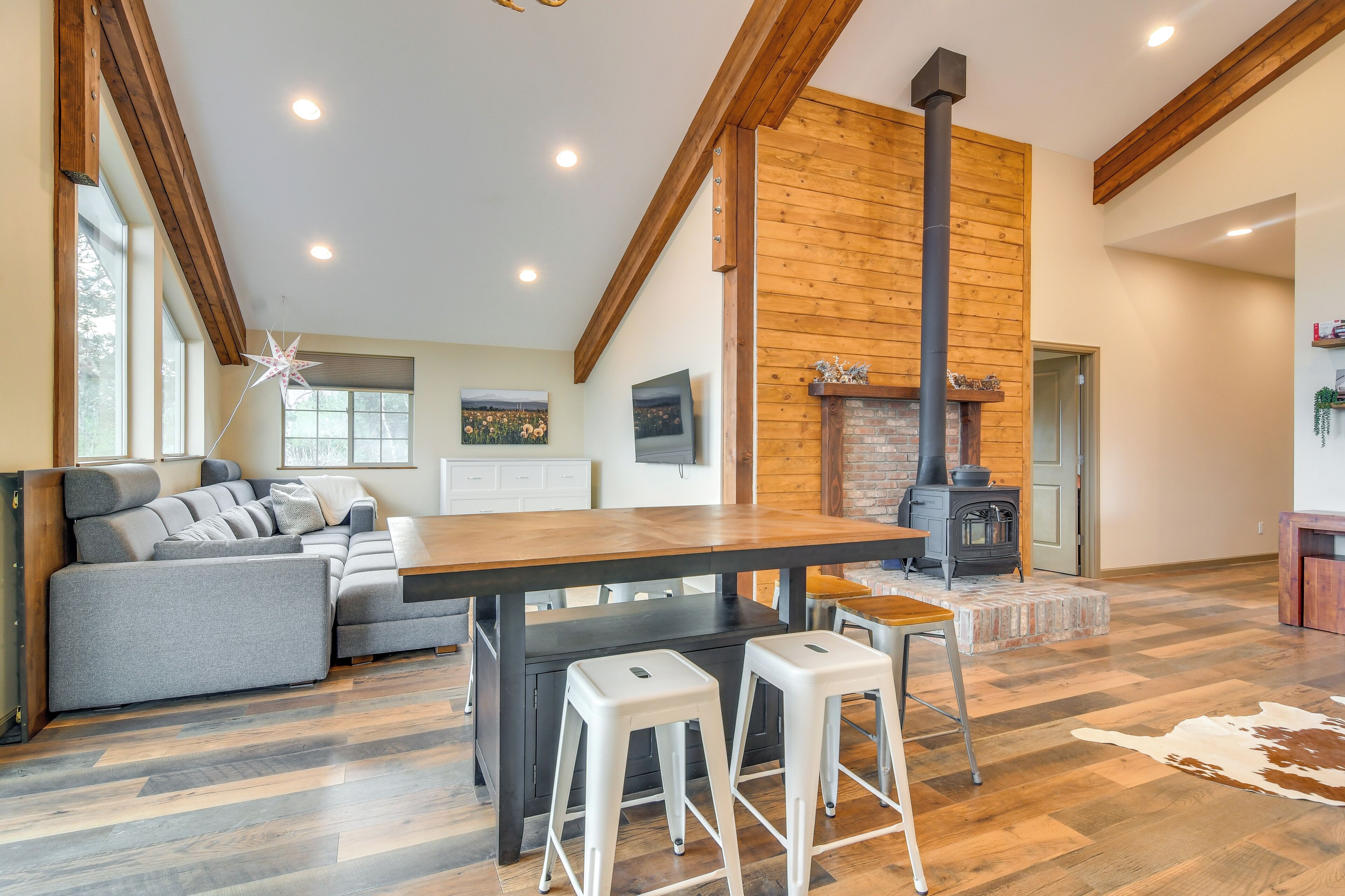Uma sala de estar moderna com lareira, vigas de madeira e padrão de piso em herringbone.