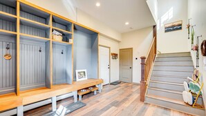 A hallway with a wooden bench, a dog bowl, and a staircase. - Pristine Cabin w/ Stables in Black Hawk by Casinos (Black Hawk)