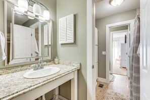 A bathroom with a granite countertop, white sink, and a large mirror with lights. - Walk to Beach: PCB Gem w/ Community Pool Access! (Panama City Beach)