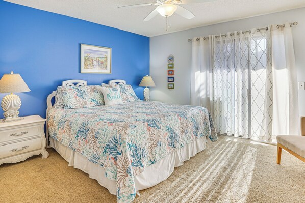 A bedroom with a bed, nightstands, a ceiling fan, and a window with curtains. - Walk to Beach: PCB Gem w/ Community Pool Access! (Panama City Beach)