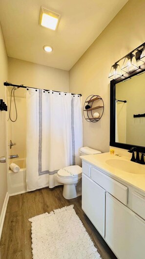 A bathroom with a shower, toilet, sink, and a mirror. - River Oaks 2BR beautiful condo (Myrtle Beach)