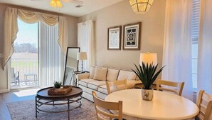 A modern living room with a sofa, a round table, and a floor lamp. - River Oaks 2BR beautiful condo (Myrtle Beach)
