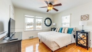 A bedroom with a bed, a ceiling fan, a TV on a stand, and a window with blinds. - 3 Mi to Hospitals: Inviting Rockford Home w/ Yard! (Rockford)