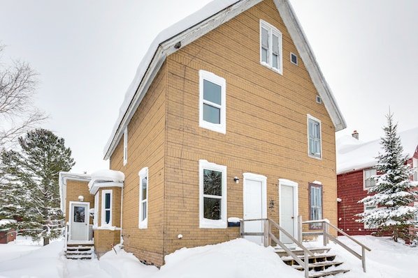 A two-story wooden house with a front porch and steps leading to the door. - 4 Mi to Lake Superior: Calumet Getaway! (Calumet)