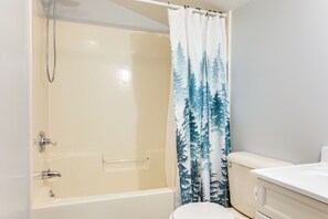 A bathroom with a bathtub, toilet, and shower curtain with a forest pattern. - 4 Mi to Lake Superior: Calumet Getaway! (Calumet)