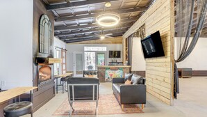 A cozy interior with a fireplace, seating area, and a TV mounted on the wall. - Georgia Farmhouse Studio w/ Hiking Trail (Lithonia)