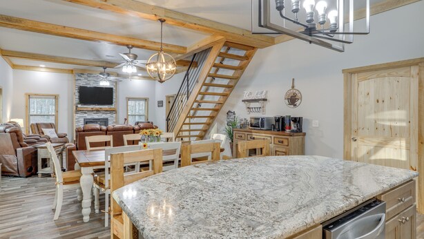 A spacious kitchen with a granite countertop, wooden cabinets, and a built-in dishwasher. - Greers Ferry Lake Access & Deck: Group Getaway! (Drasco)