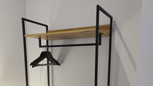 A bunk bed with a wooden shelf and a hanging rack. - Leicester Square 2nd Floor Studio (London)