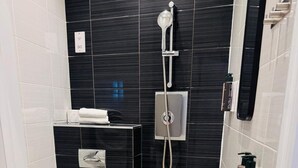 A modern bathroom with a toilet, a shower, and a sink. - Leicester Square 2nd Floor Studio (London)