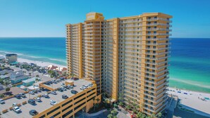 Um hotel imponente com vários andares, uma garagem de estacionamento e vista para a praia.