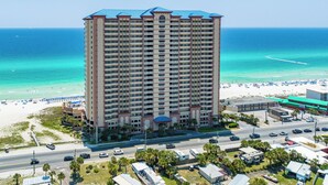 A tall hotel with a blue roof, located near a beach with clear turquoise waters. - Beachfront with unbeatable views, 3BR 2BA Condo at Sunrise Beach! (Panama City Beach)