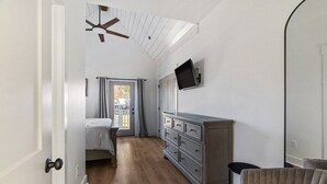 A room with a bed, a dresser, a television, and a ceiling fan. - On Reel Time at River Rocks Plantation (Guntersville)