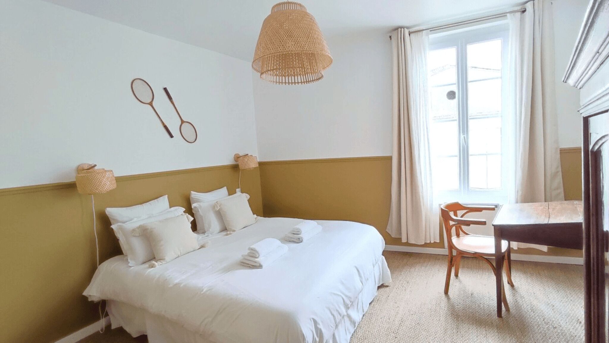 Una camera d'albergo con un letto, una scrivania e una finestra.