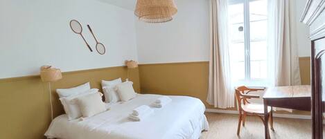 Una camera d'albergo con un letto, una scrivania e una finestra.