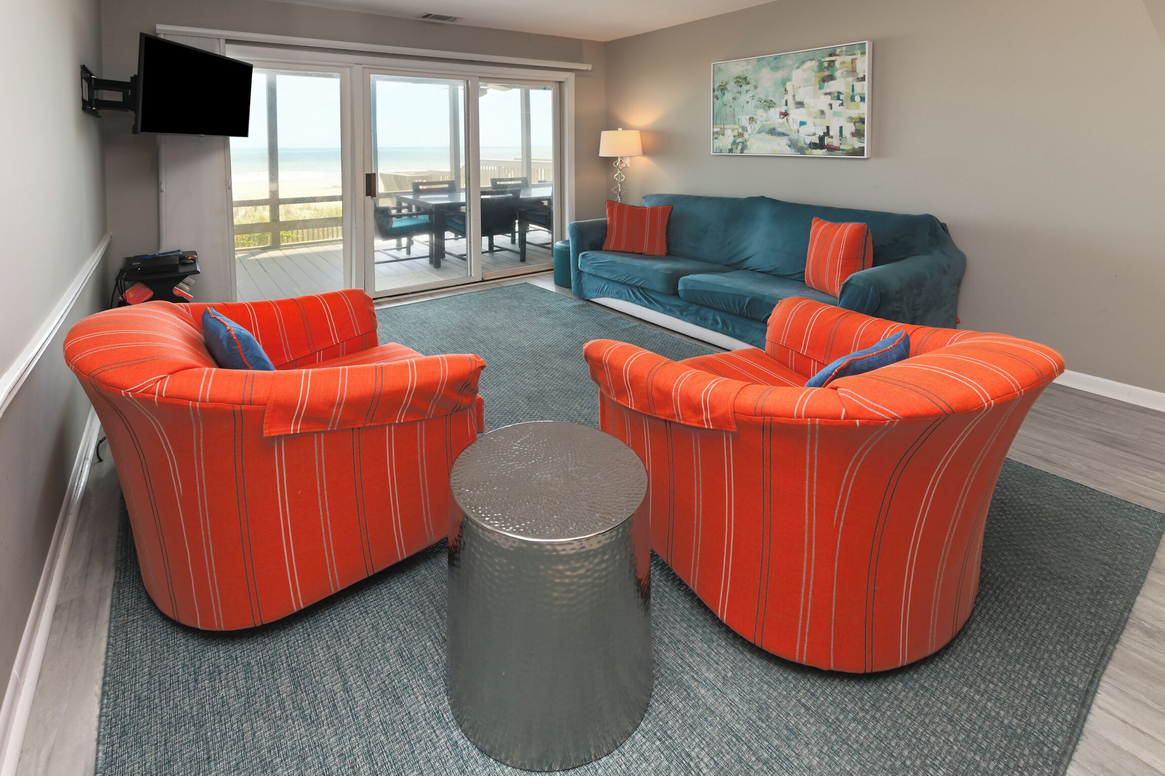 A living room with a sofa set, a coffee table, and a TV mounted on the wall.